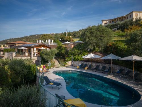 a large swimming pool with chairs and umbrellas at Residence Ca Del Lago in Torri del Benaco