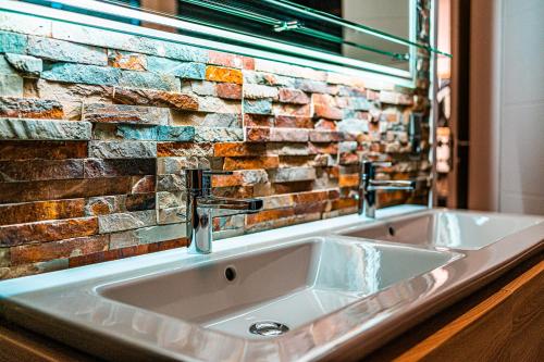 a bathroom sink in front of a brick wall at Poolhaus Bodensee ideal für Geschäftsreisende in Wasserburg