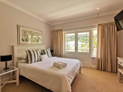 sypialnia z dużym białym łóżkiem i oknem w obiekcie River Club 4213 w mieście Plettenberg Bay