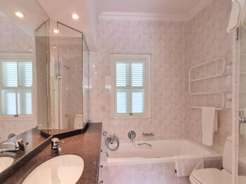 a bathroom with a tub and a toilet and a sink at River Club 4213 in Plettenberg Bay