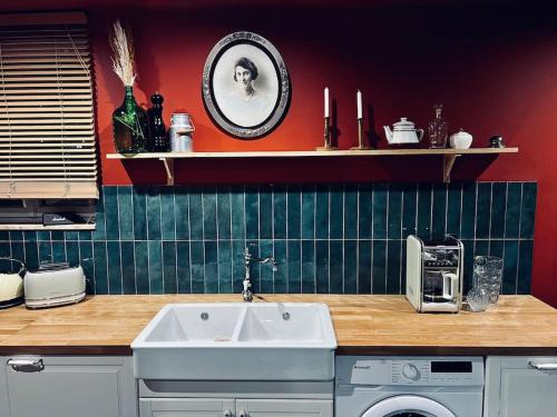 uma cozinha com um lavatório e uma bancada em Le gite. em Paluel
