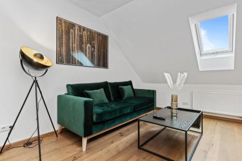 a living room with a green couch and a table at Casa Industrial: Design, Nespresso, Flughafennähe in Freising