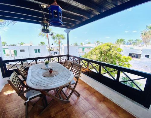 a table and chairs on a balcony with a view of the ocean at Villa muy cerca de la Playa. in Tías