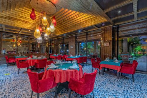 a restaurant with red tables and red chairs at Amara Luxury Resort & Villas in Kemer