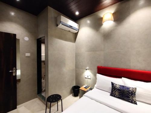 a bedroom with a bed and a red headboard at Hotel Eros - Near Mumbai International Airport T2 in Mumbai