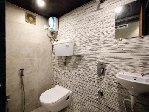 a bathroom with a toilet and a sink at Hotel Eros - Near Mumbai International Airport T2 in Mumbai