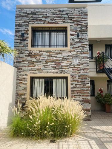 un edificio de piedra con una ventana y algunas plantas en Hermoso Departamento Azulino en Mendoza