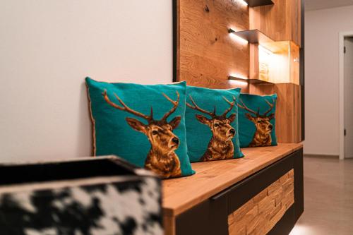 three deer head pillows on a table with a pillow at Poolhaus Bodensee ideal für Geschäftsreisende in Wasserburg am Bodensee