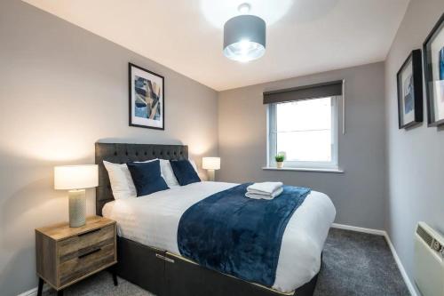 een slaapkamer met een groot bed en een raam bij Fabulous Quayside Apartment with Free Parking in Liverpool