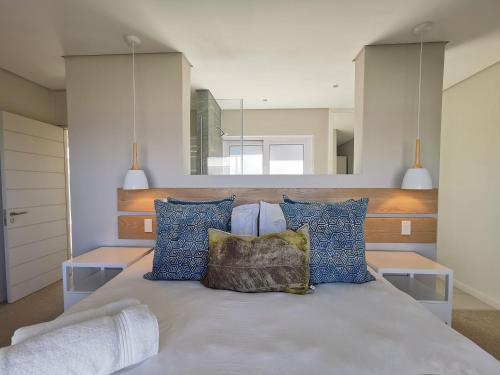 a bedroom with a bed with blue pillows at Betty in Plettenberg Bay