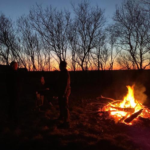 a group of people standing around a fire at Børnenes in Spottrup