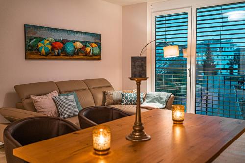 a living room with a table and a couch at Poolhaus Bodensee ideal für Geschäftsreisende in Wasserburg am Bodensee