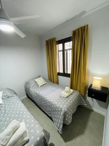 um quarto com 2 camas e uma janela em Hermoso Departamento Azulino em Mendoza