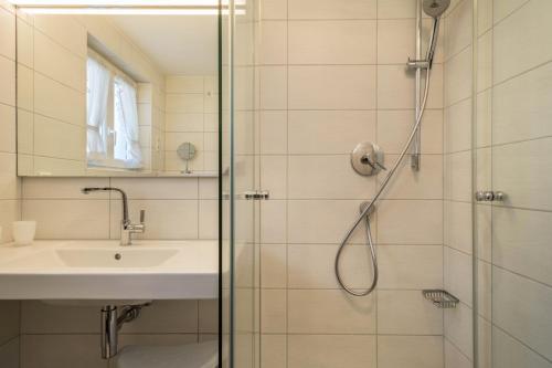 ein Bad mit einer Dusche und einem Waschbecken in der Unterkunft Haus Kees - Wohnung 1 in Kressbronn am Bodensee
