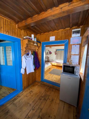 a tiny house with a blue door and a microwave at Căsuța Tivadar in Breb