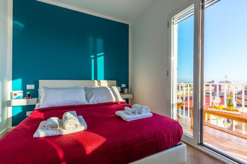Poerio Rooftop Luxury apartament في نابولي: غرفة نوم بسرير احمر عليه مناشف