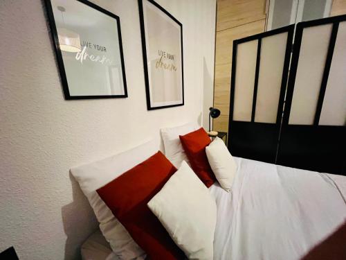 a bedroom with a bed with red and white pillows at MARCO POLO - Studio privé avec piscine et parking in Mandelieu-La Napoule