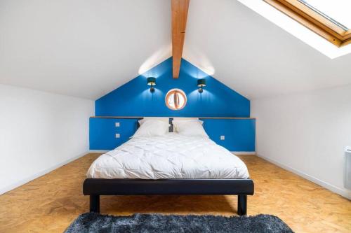 a bed with a blue headboard in a room at Maison au bord de la Moselle in Argancy