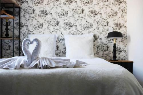 a bedroom with a bed with two swans on it at L'antichambre, neuf avec jardin à 100m de la mer in Donville-les-Bains