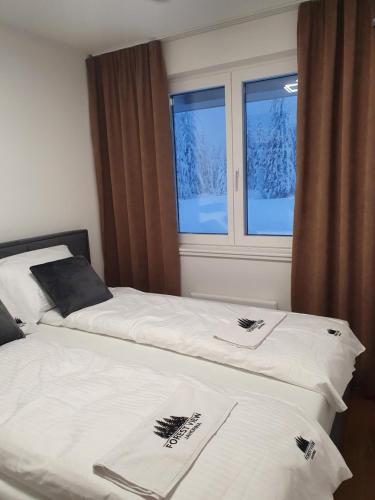 - 2 lits dans une chambre avec de la neige à l'extérieur de la fenêtre dans l'établissement Jahorina Forest View, à Jahorina