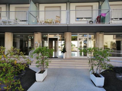 ein Gebäude mit Topfpflanzen davor in der Unterkunft Appartamento vista mare in Lido di Jesolo