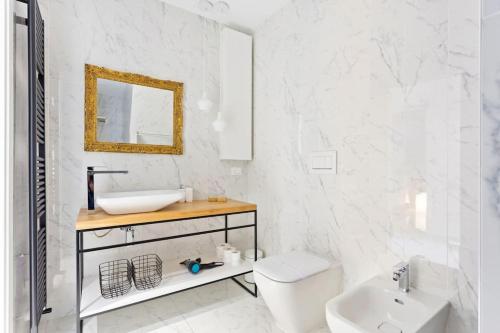 a white bathroom with a sink and a toilet at Dimora San Lorenzo Luxury Apartment in Venice