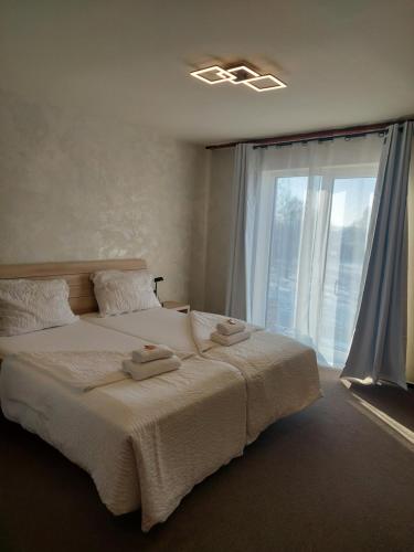 a bedroom with a large bed and a window at Penzion Country Steak Restaurant in Lanškroun