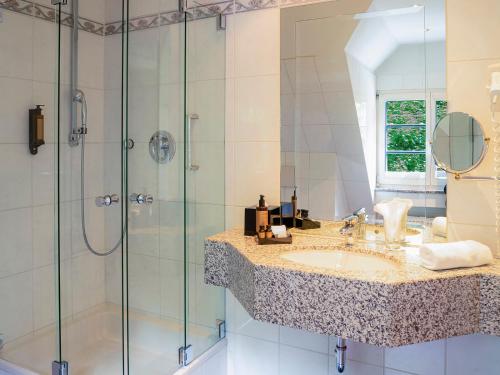 a bathroom with a sink and a shower at Romantik Hotel-Restaurant Altenberger Hof in Odenthal