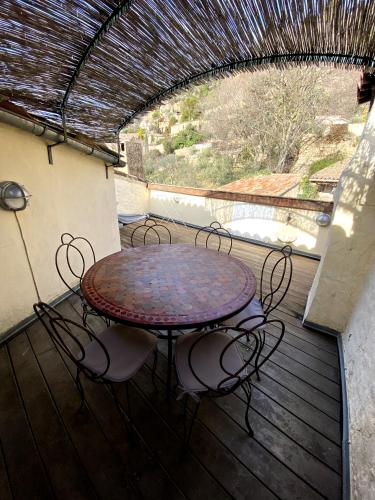 une table et des chaises assises sur une terrasse en bois dans l'établissement L'Oustau de Cotignac, à Cotignac