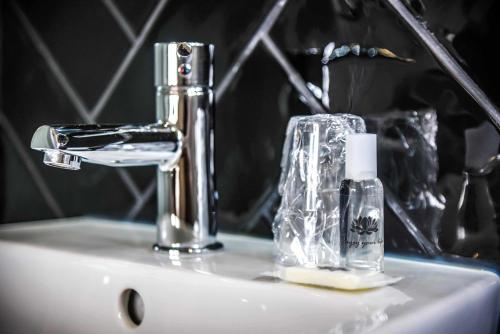 a bathroom sink with a toothbrush and a faucet at Hotel Singular Porto Aeroporto in Maia