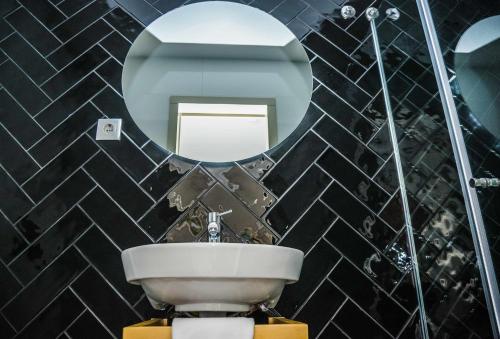 a bathroom with a sink and a mirror at Hotel Singular Porto Aeroporto in Maia