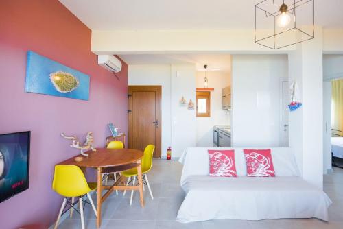 a bedroom with a bed and a table and chairs at Nereus & Oceanus Beachfront Apartments, Lagonisi Beach #FeelsLikeHome in Ormos Panagias