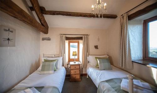 a bedroom with two beds and a window at Garth Cottage, Castle Carrock, Nr Carlisle in Castle Carrock