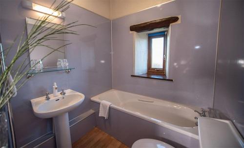 a bathroom with a sink and a tub and a toilet at Garth Cottage, Castle Carrock, Nr Carlisle in Castle Carrock