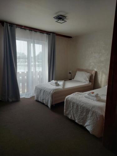 a hotel room with two beds and a window at Penzion Country Steak Restaurant in Lanškroun