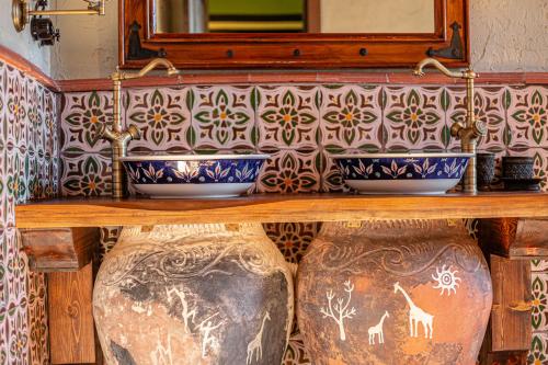two large vases sitting on top of a wooden shelf at Knyazli Family Suites & Rooms in Kiçik Qaramurad