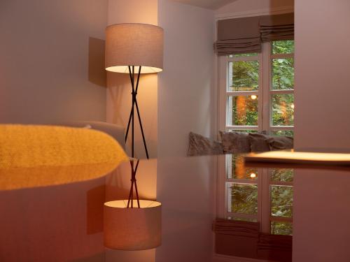 a lamp in the corner of a room with a window at Romantik Hotel-Restaurant Altenberger Hof in Odenthal