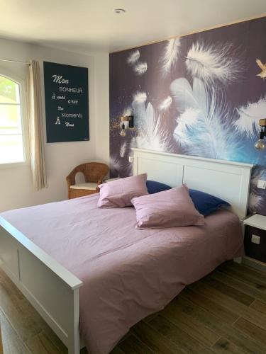 ein Schlafzimmer mit einem großen Bett mit rosa Kissen in der Unterkunft Entre Ciel Et Nature in Venterol