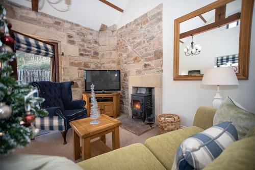 a living room with a christmas tree and a fireplace at Oak Cottage, Castle Carrock, Nr Carlisle in Castle Carrock