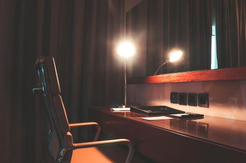 a desk with a chair in a room at Velvet Hotel Jeddah in Jeddah