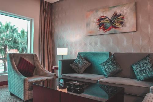 a living room with a couch and a chair at Velvet Hotel Jeddah in Jeddah