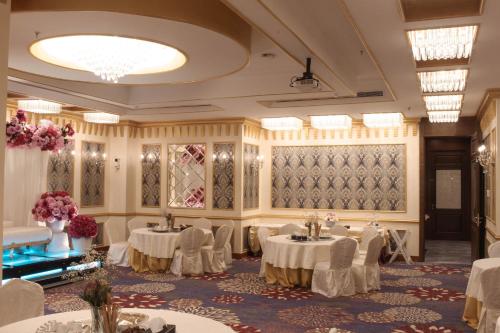 a banquet hall with tables and chairs and flowers at Velvet Hotel Jeddah in Jeddah