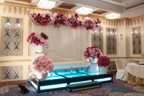 a room with a bench and flowers on the wall at Velvet Hotel Jeddah in Jeddah