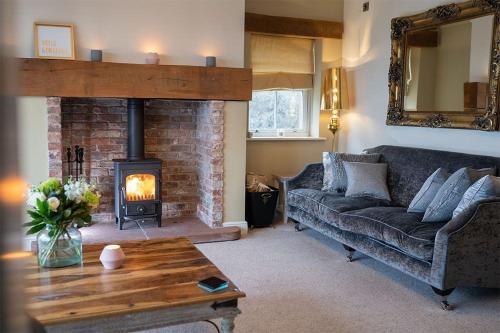 a living room with a couch and a fireplace at Orchard House, Castle Carrock, Nr Carlisle in Castle Carrock
