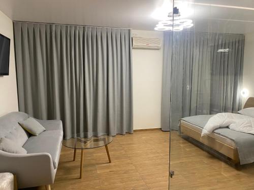 a bedroom with a bed and a couch and a window at Едем in Brzezhany