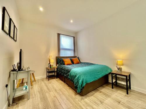 a bedroom with a bed and a tv and a window at Dunamis Staycation 4 in Croydon
