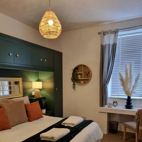 1 dormitorio con 1 cama con cabecero verde y ventana en Inverness City Centre Flat, en Inverness