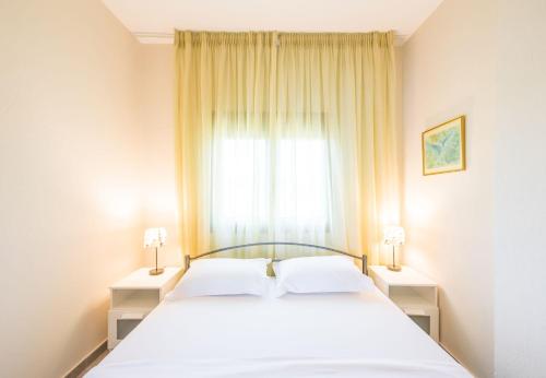 a bedroom with a white bed and a window at Nereus & Oceanus Beachfront Apartments, Lagonisi Beach #FeelsLikeHome in Ormos Panagias