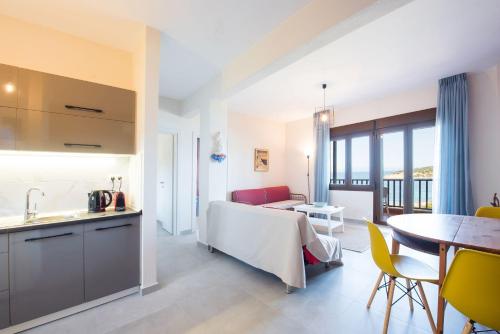 a kitchen and a living room with a table at Nereus & Oceanus Beachfront Apartments, Lagonisi Beach #FeelsLikeHome in Ormos Panagias