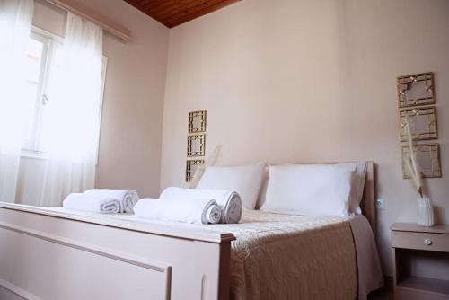 una camera da letto bianca con un letto e asciugamani di The Homey a Sidari